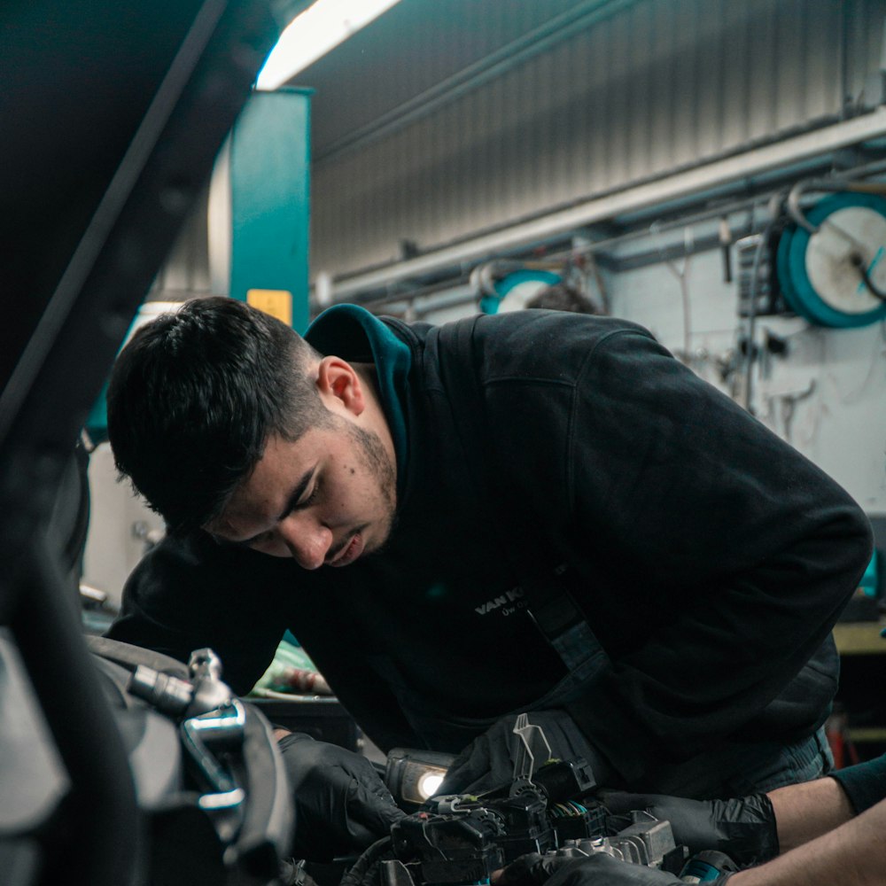 Mecánico revisando el motor de un coche en el taller